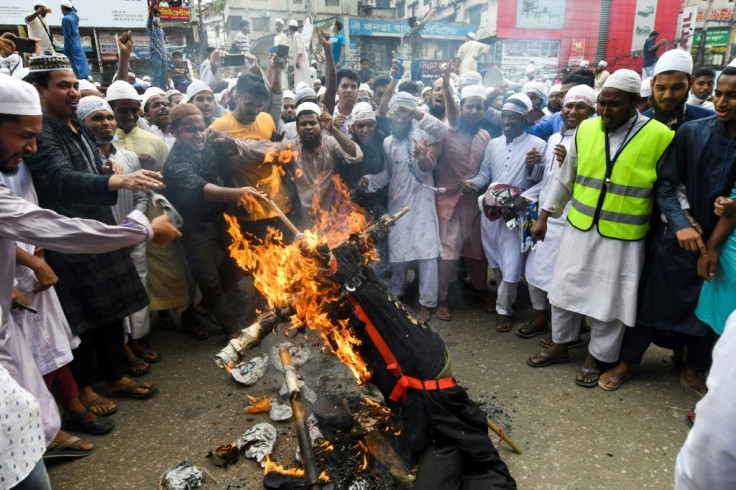Protesters set an effigy of French President Emmanuel Macron on fire during an anti-France demonstration in Dhaka