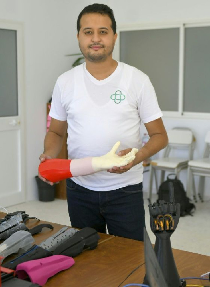 Tunisian engineer Mohamed Dhaouafi, who launched his start-up in 2017 from his parents' home, holds a prototype of an artificial hand