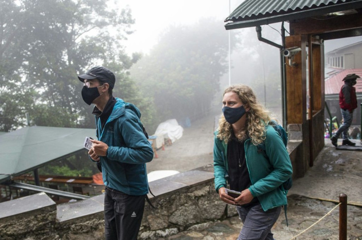 French citizens, Veronique (R) and Arnaud arrive at Machu Picchu, in Cusco, Peru on November 2, 2020, as the first tourists allowed in after eight months of coronavirus lockdown