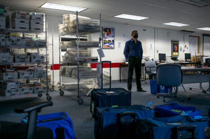 Lansing City Clerk Chris Swope stands amidst sealed containers of counted ballots following the end of vote counting Lansing, Michigan