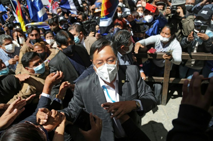 Bolivian President-elect Luis Arce is greeted by supporters after getting his credentials, outside the Central Bank's auditorium in La Paz on October 28, 2020.