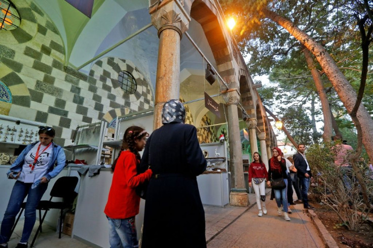 Visitors tour a trade fair dedicated to war-hit businesses from Aleppo looking to make a revival in the Syrian capital Damascus