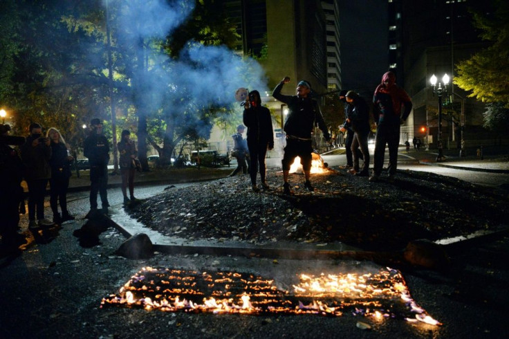 A handful of protesters burn the American flag outside a Portland Courthouse