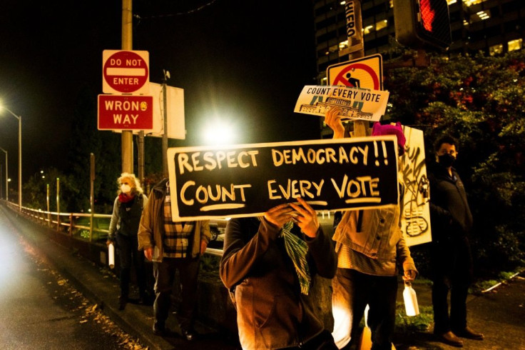 A protester holds a sign reading 'Respect democracy! Count every vote' during a demonstration in Portland, Oregon