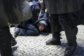 Police officers hold down a protester during the anti-lockdown rally in Ljubljana on Thursday