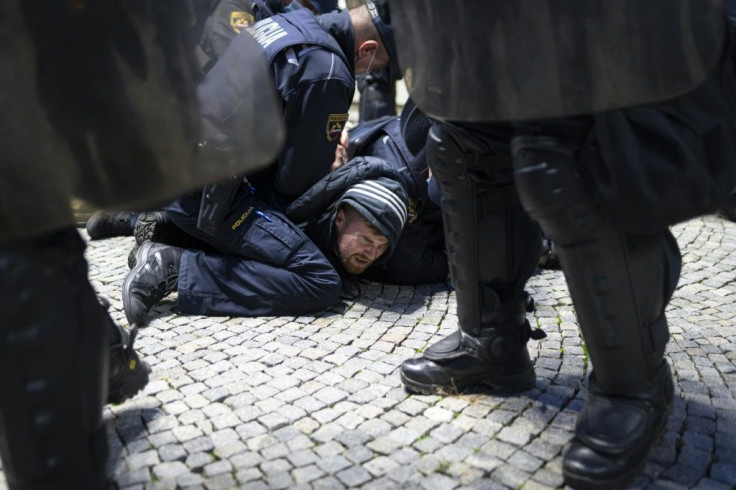 Police officers hold down a protester during the anti-lockdown rally in Ljubljana on Thursday