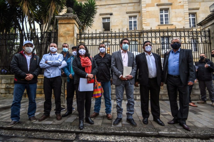 Former guerrilla leaders and current members of the Common Alternative Revolutionary Force (FARC) political party pose outside the presidential palace in Bogota, Colombia, before meeting with President Ivan Duque, in November 2020