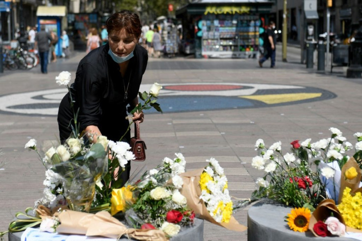 A woman leaves flowers on Barcelona's Las Ramblas boulevard, where one of the attackers rammed a van into pedestrians