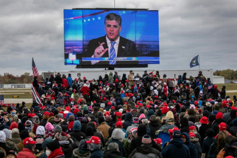A large screen shows Fox News anchor Sean Hannity at a Trump rally in Waterford, Michigan on October 30, 2020
