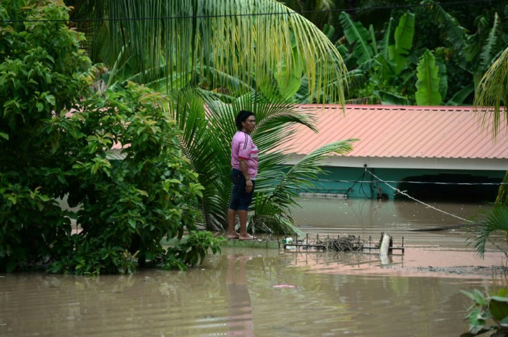 A woman stands near a house in Omonita, El Progreso municipality, Yoro department, Honduras, on November 6, 2020, after the passage of Eta