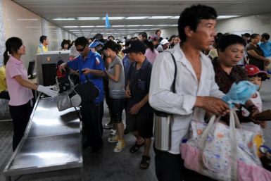 Chinese plainclothes security check bags of tourists as they enter Tiananmen Square in August 2008 ahead of the Olympics when Beijing warned of attacks by the shadowy East Turkestan Islamic Movement, which the United States has concluded does not exist