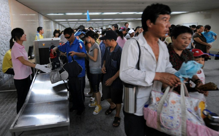 Chinese plainclothes security check bags of tourists as they enter Tiananmen Square in August 2008 ahead of the Olympics when Beijing warned of attacks by the shadowy East Turkestan Islamic Movement, which the United States has concluded does not exist