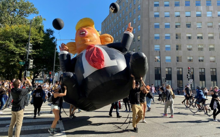 People carry a Trump inflatable as they celebrate on Black Lives Matter plaza across from the White House