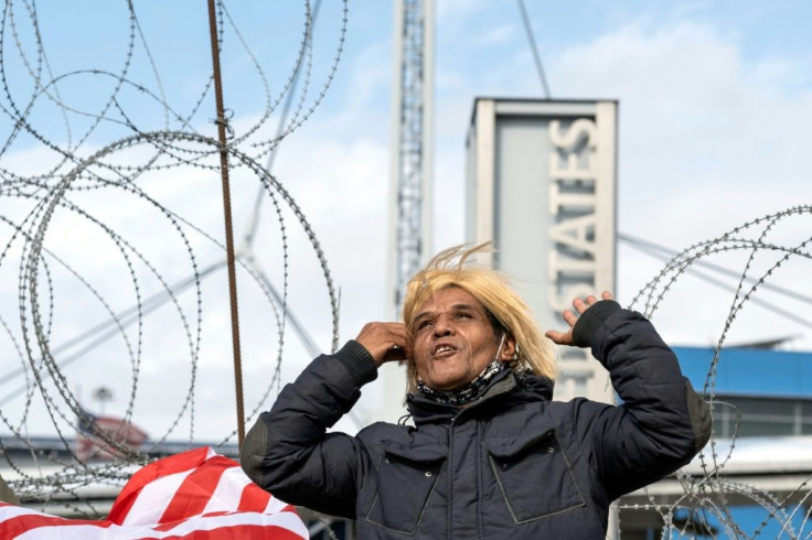 An activist impersonating Donald Trump celebrates Joe Biden's election victory on the US-Mexican border