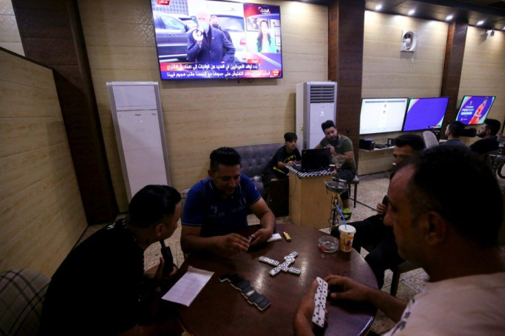 Iraqis gather at a cafe in Baghdad's Karrada neighbourhood on the day of the US presidential election, with news coverage of that poll airing on television