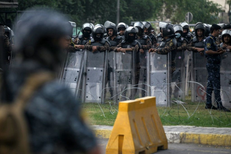 Iraqi riot policemen stand guard during Saturday's demonstration in Baghdad