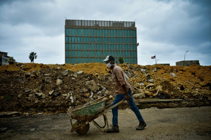 A construction worker pushes a wheelbarrow near the Embassy of the United States of America in Havana, which was closed by President Donald Trump