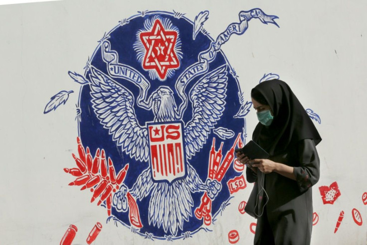 A woman walks past a mural painted on the outer walls of the former US embassy in the Iranian capital Tehran