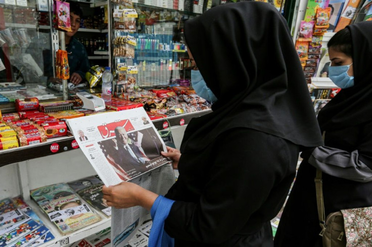 A customer in Tehran browses the front page of an Iranian newspaper featuring the results of the US presidential election