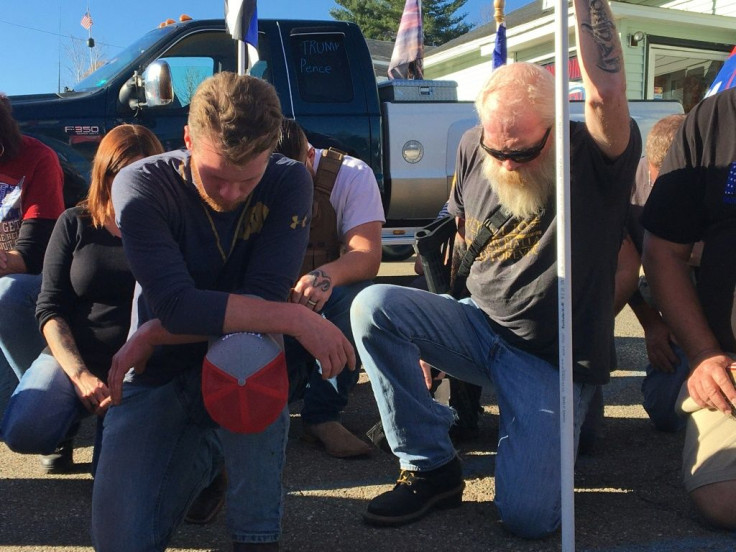 Eamon Daley (L), 28, and other supporters of President Donald Trump kneel to pray outside Jones Diner in Towanda, Pennsylvania