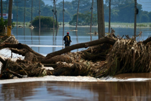 A man wades through floodwaters from Hurricane Eta in La Lima, in the Cortes department of Honduras, in November 2020