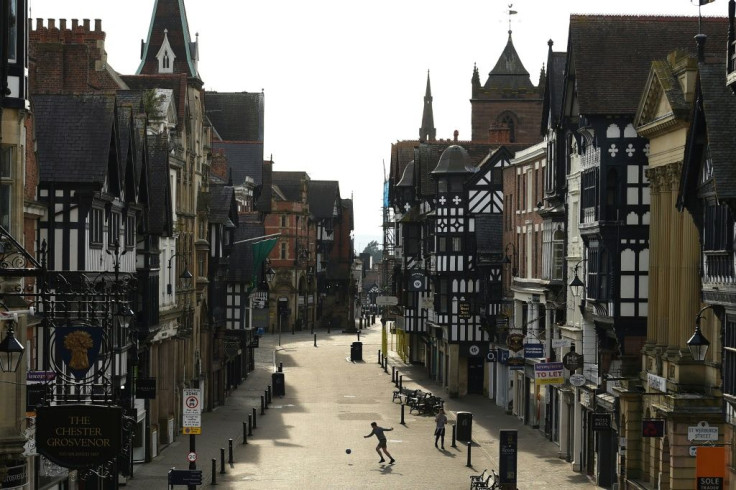 A man plays with a football in a near-deserted Chester city centre during the lockdown in England in April