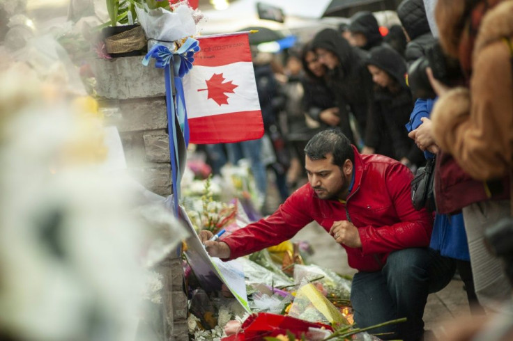 A man writes a message at a memorial near the site of the deadly van attack in April 2018 in Toronto