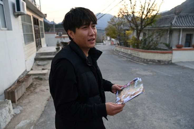 Gao Shan looks at a photo of himself shaking hands with Joe Biden in 2001