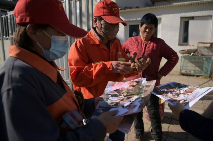 Villagers looking at 2001 photos of then-US Senator Joe Biden visiting their village, Yanzikou, north of Beijing