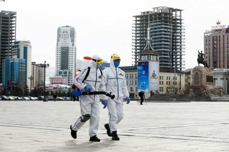 Health workers spray disinfectant in Sukhbaatar square in Ulaanbaatar in March 2020. The country has just recorded its first local transmissions of the coronavirus