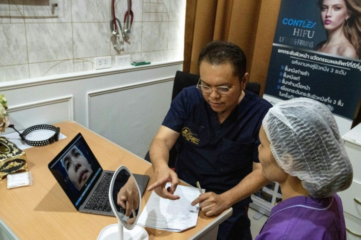 Thai surgeon Sakirin Al-Ishak explains the procedure to a patient waiting for plastic surgery in Bangkok