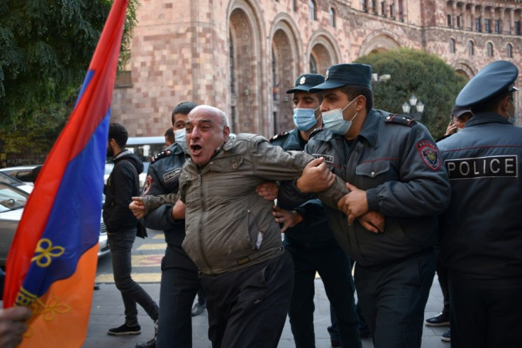 Armenian police officers detain a protestor near the government headquarters.