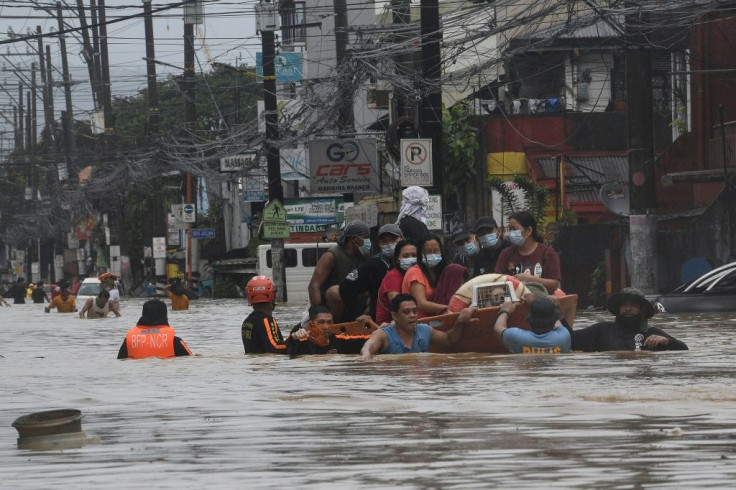 Rescuers evacuate residents from their flooded homes in Manila