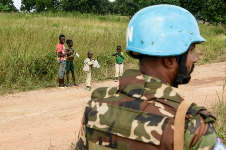 Children look at a United Nations Bangladeshi soldier, part of the MINUSCA peacekeeping force in the Central African Republic