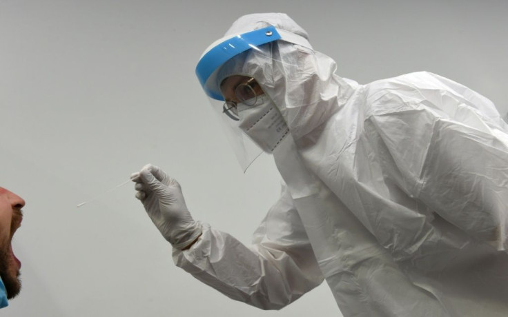 A health worker takes a smear at the new Lufthansa coronavirus test center in Munich airport