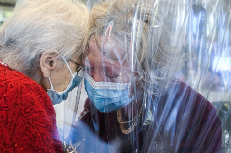 A resident at the Domenico Sartor nursing home near Venice hugs her visiting daughter through a plastic screen in a so-called "Hug Room"