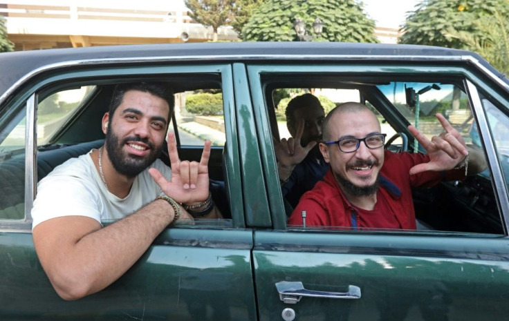 Best friends Bader al-Hajjami (R) and Ahmad Moussa pose during a car ride in Syria's capital Damascus; Bader is paralysed from the waist down, while Ahmad cannot hear or speak