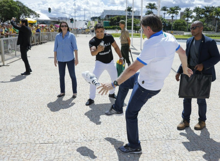 Brazilian President Jair Bolsonaro kicks a dummy of Lula da Silva after a protest against the National Congress and the Federal Supreme Court, in Brasilia, on March 15, 2020