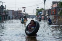 A boy wades through a flooded street in the Mexican city of Villahermosa. Thousands of people in Tabasco state have been forced to seek refuge in shelters due to flooding brought by Hurricane Eta and dischrge from an overflowing dam