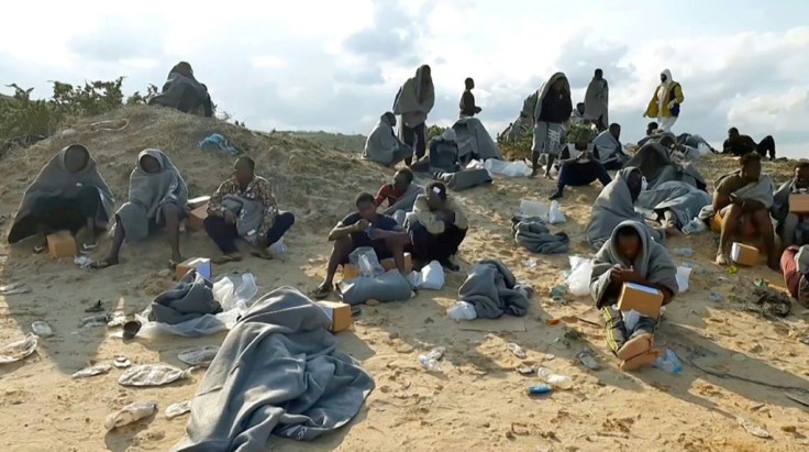 Survivors sit on the shore in Khoms on Thursday. The IOM said that so far this year, at least 900 people had drowned in the Mediterranean trying to reach European shores