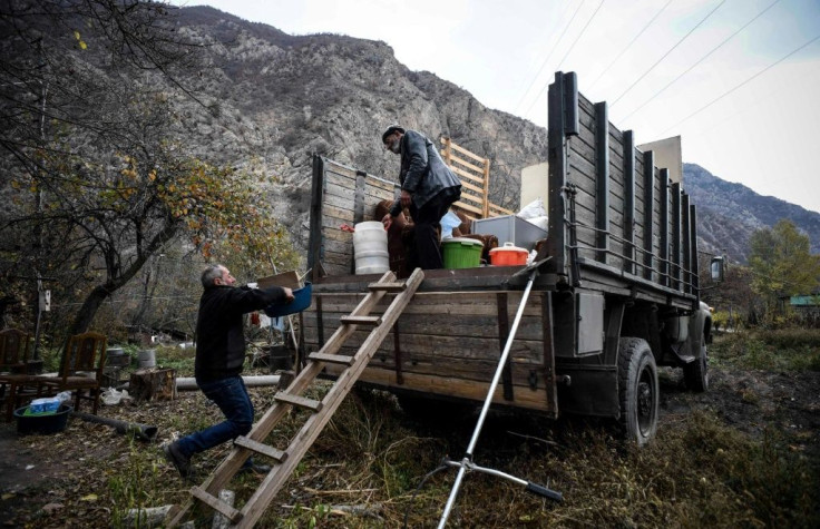 Armenians pack their belongings as they leave their house in Kalbajar, which is being handed over to Azerbaijan