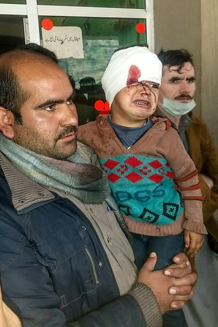 A Pakistani Kashmiri carries an injured child at a hospital following deadly cross-border shelling between Pakistani and Indian forces
