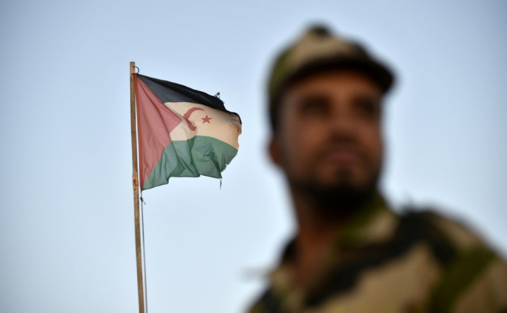 (FILES) In this file photo uniformed soldiers of the pro-independence Polisario Front of the disputed Western Sahara stand before a Sahrawi flag flying at the Boujdour refugee camp near the town of Tindouf in Western Algeria; the territory's ceasefire has