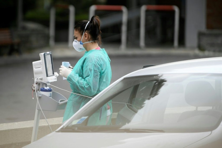 A medical worker provides oxygen to a suspected Covid-19 sufferer in her car outside the Cotugno hospital in Naples