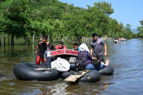 Residents evacuate a flooded area in Baracoa, Honduras on November 8, 2020
