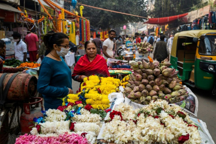 People buy flowers for Diwali, the Hindu Festival of Lights, from a vendor in a market area in New Delhi on November 14, 2020.