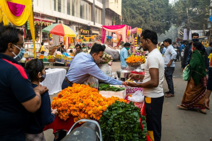 A vendor sells marigold flowers for Diwali at a market area in New Delhi