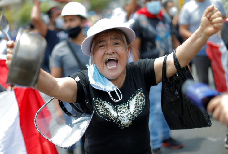 A woman celebrates outside the Congress in Lima after Peru's unpopular interim president Manuel Merino stepped down after days of protests