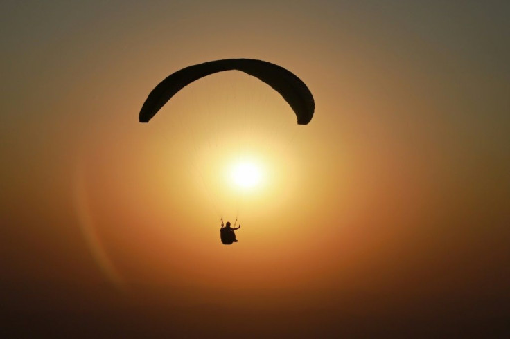 An elderly Australian man has survived a paragliding crash, walking away relatively unscathed after crashing into the sea near Sydney