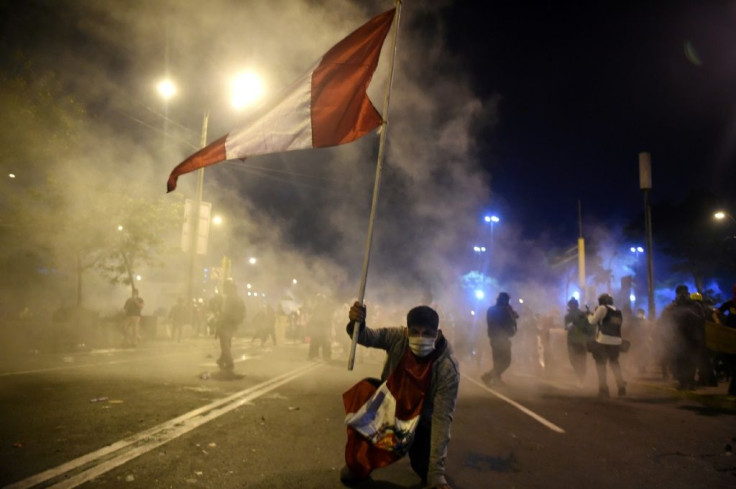 A supporter of ousted Peruvian President Martin Vizcarra holds a Peruvian flag during a protest against the government of interim president Manuel Merino in Lima on November 14, 2020